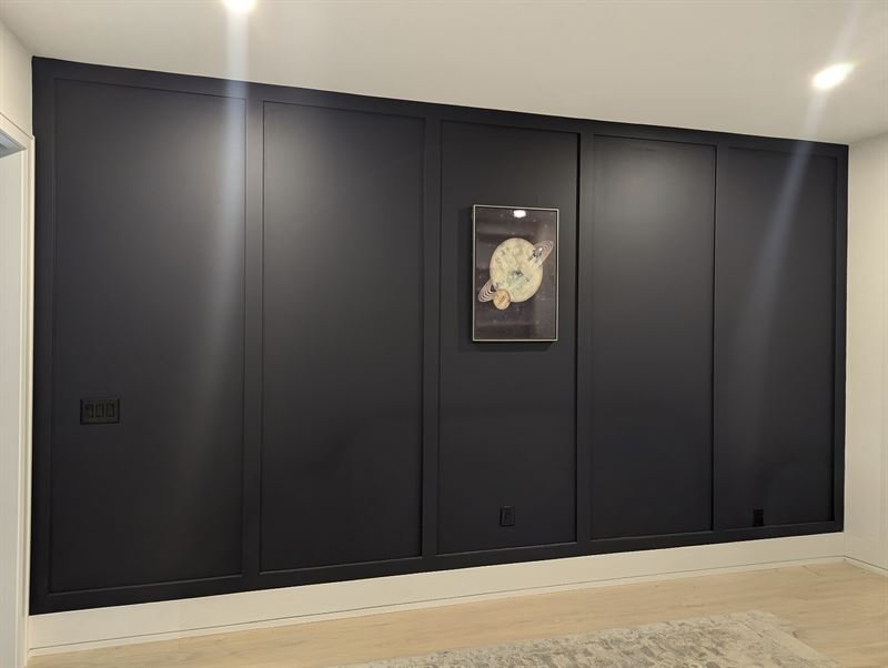 Interior board and batten wall in near-black with wide spacing between the battens