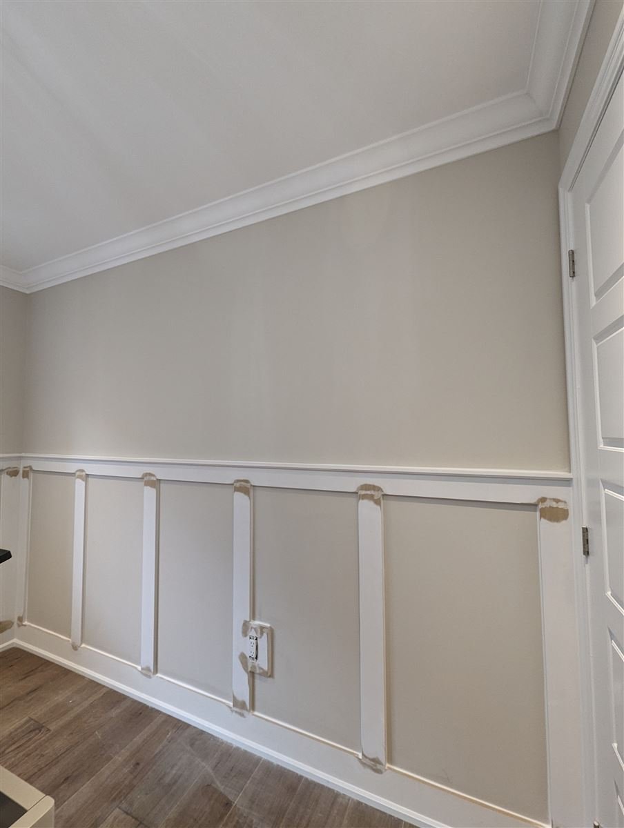 Interior board and batten wall before paint, showing the top rail, the battens and the filled nail holes