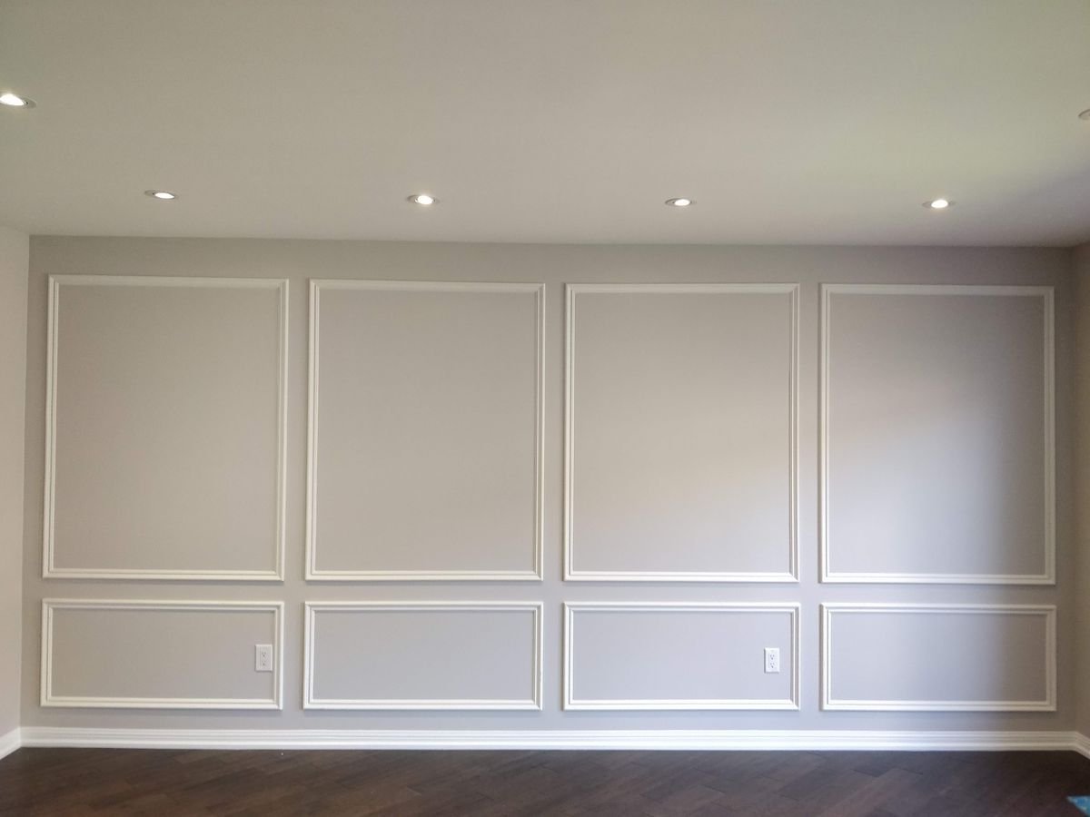 Interior panel moulding accent wall with two rows of boxes, a shorter row under a taller row, all in one gray colour