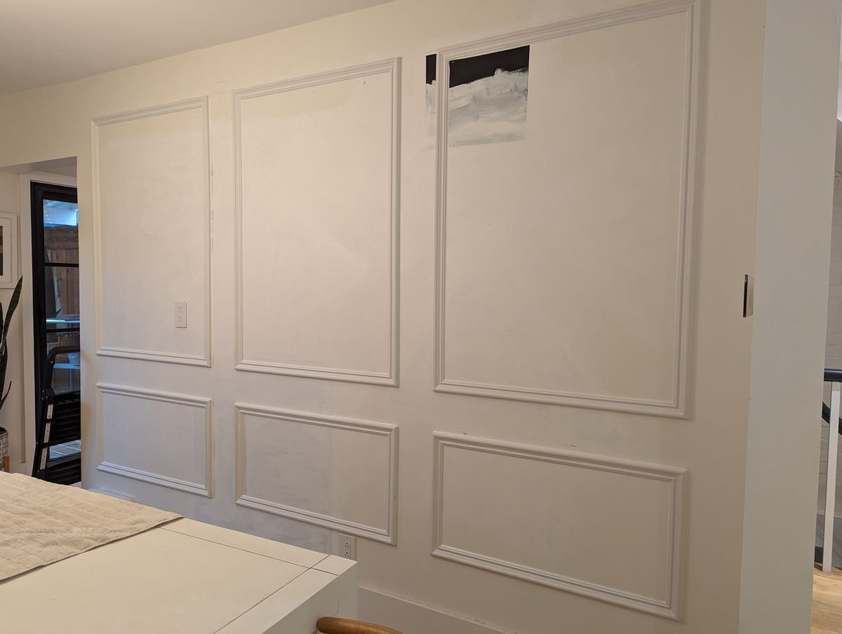 Interior panel moulding wall before paint, boxes installed with filled pin holes and patched drywall showing